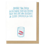Blue, handwritten text centered at the top of the card that says "another year closer to becoming that old person who pops out their dentures to scare children for fun." A hand-drawn illustration of dentures in a glass of water below it.