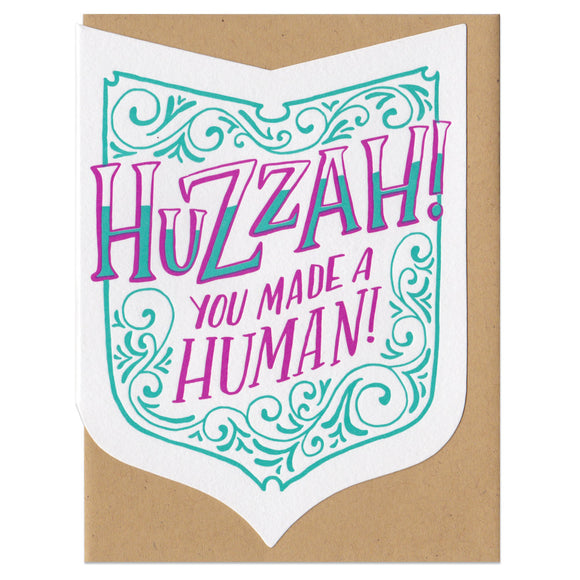 A shield shape die-cut greeting card with kraft paper envelope. Festive hand-drawn text that reads 