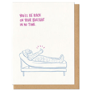 greeting card which reads "you'll be back on your bullshit in no time" featuring an illustration of a person in a body cast giving a thumbs-up
