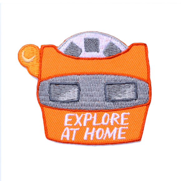 An embroidered iron on patch die cut in the shape of a vintage orange view finder with text that says 
