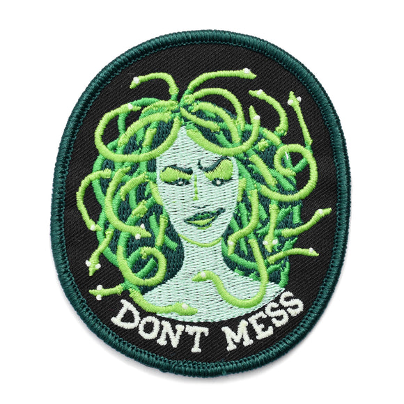 A patch of a green medusa with snakes for hair and 