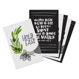 A set of 6 postcards, 3 postcards that have an eagle holding an olive branch with text that says "Hold fast", and 3 black postcards with handlettered text reading, "Our lives begin to end the day we become silent about the things that matter. - Martin Luther King, Jr"