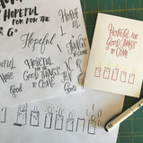 A greeting card and envelope featuring 5 partially burned lit candles with text that says "hopeful for good things to come."