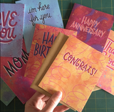 The word "congrats!" handwritten in purple, surrounded by abstract yellow, red, and orange swirls, circles, and blobs