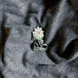 An enamel pin with a rubber backer in the shape of a Doc Marten black boot with a white daisy coming out of it. floral, flowers, daisies, boots, 90s, pins, button, pin, enamel pin, accessories, flair