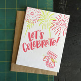 Greeting card and kraft paper envelope. Text reads, "Let's celebrate!" Illustration of fireworks with dog below, shaking, holding a sign that says, "quietly."