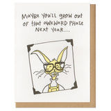 greeting card with an illustrated bunny wearing glasses, overall, and braces which reads "maybe you'll grow out of that awkward phase next year..."