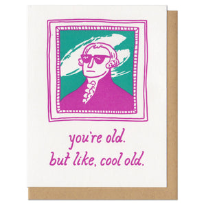 greeting card with a pink and teal illustration of George Washington wearing sunglasses in frame. Text below reads, "you're old. but like, cool old"