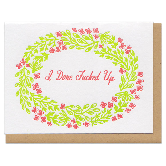 A greeting card and envelope featuring green red florals surrounding text that reads 