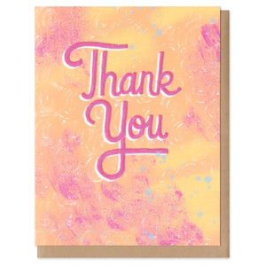 A greeting card and envelope featuring hand lettered text in pink that says, "thank you" with a orange and pink textured background. thanks, thank you, gratitude, card, greeting card