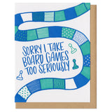 white greeting card with a patterned teal and blue board game track and game piece illustration surrounding hand-lettering that reads "sorry i take board games too seriously"