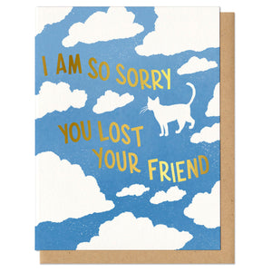 blue greeting card with a white cloud pattern featuring the silhouette of a cat. gold foil stamped lettering reads "i am so sorry you lost your friend"