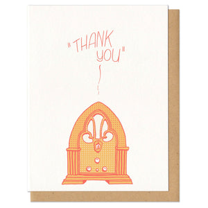 white greeting card with an illustrated old fashioned radio, printed in orange, beath hand-lettering that reads "thank you"