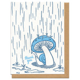 white greeting card witn an illustration of a snail hiding from the rain beneath a mushroom next to hand-lettering that reads "thank you"