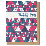 white greeting card with a red and blue illustrated triangles pattern and hand lettering that reads "thank you"