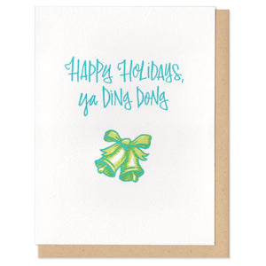 A greeting card and envelope featuring script that says "Happy holidays, ya ding dong" with a green bell below it.