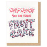 A greeting card and envelope featuring script that says "Happy holidays from your favorite" with "fruit cake" written below in the shape of an actual fruitcake.