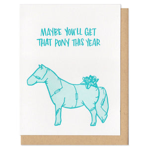 Greeting card and kraft paper envelope. Teal, hand-written text that reads, "Maybe you'll get that pony this year." Illustration of pony wrapped in wrapping paper with bow below text. Shades of teal.
