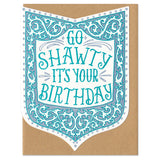 Die-cut shield-shape greeting card and envelope. Card reads "go shawty it's your birthday" in ornate, hand written, blue type. Surrounded by an ornate border in shades of blue.