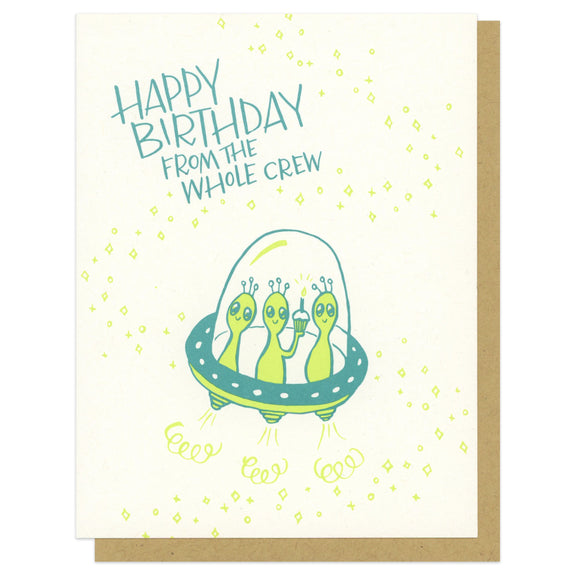 A greeting card with an envelope featuring a UFO and three aliens with text that says Happy Birthday From the whole Crew
