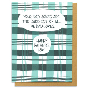 A greeting card and kraft envelope featuring all over printed green and seafoam plaid with a text bubble that says, "your dad jokes are the daddiest of all the dad jokes. Happy Father's Day."