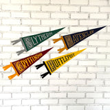 The four houses of Harry Potter reimagined to be pennants. Green Slytherin with a snake in the S, navy ravenclaw with a raven in the R, red gryffindor with a lion in the G, and a yellow hufflepuff with a badger in the H