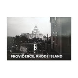 postcard of a black and white photograph of the RI state house at night behind some buildings and trees. white text reads "Providence, Rhode Island"