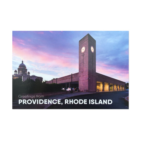 postcard photograph of the providence train station at dusk with the state house visable in the background. white text at the bottom reads 