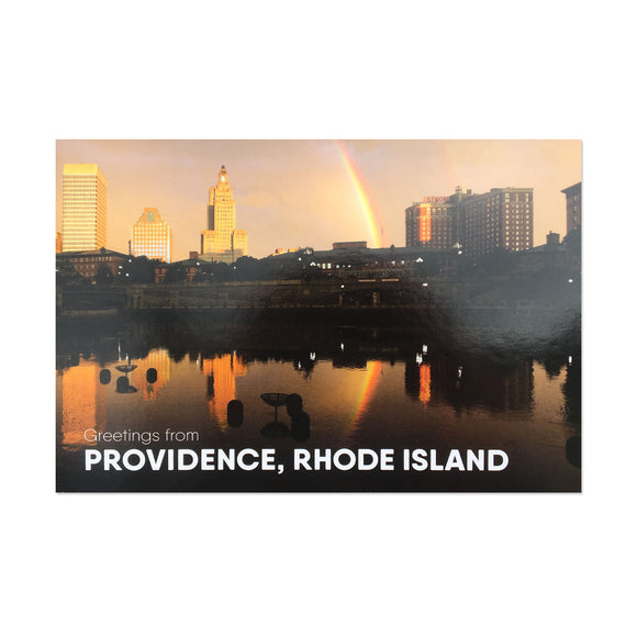 postcard phtoograph of the Providence skyline with a rainbow and white text on the bottom reading 