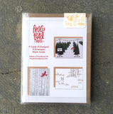 A box set of greeting cards featuring 3 designs. From left to right: A greeting card with birch trees and a cardinal flying in front of it. A greeting card featuring rows of Christmas trees for sale with twinkle lights and a deer meandering in between. A greeting card showing a snow covered ground with patches of grass and a white rabbit.