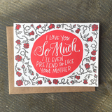 Greeting card and kraft paper envelope. Grey and red thorny roses surround handwritten type that reads, "I love you so much, I'll even pretend to like your mother."