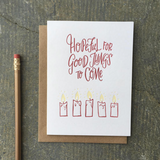 A greeting card and envelope featuring 5 partially burned lit candles with text that says "hopeful for good things to come."