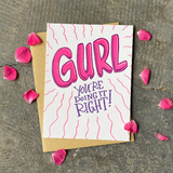 Greeting card and kraft paper envelope. Text in bubble letters reads "GURL" and below it hand written, "You're doing it right!" Bright pink and purple.