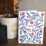 white greeting card with red  hand-lettering that reads "mom" surrounded by red and green illustrated tulips pictured with a potted plant