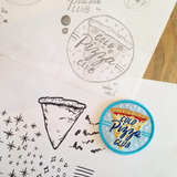 A blue patch that says, "cold pizza club" against a slice of pizza next to the original sketches on white paper of the patch.