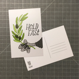 A postcard featuring an eagle's talons holding an olive branch with scripted text next to it that says, "hold fast."